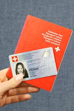 main qui tient une carte d'identité ainsi qu'une passeport suisse